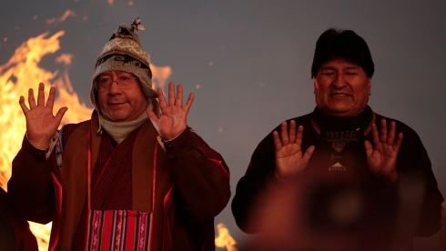 El presidente de Bolivia Luis Arce y el ex presidente Evo Morales levantan sus manos como parte de un ritual de celebración del solsticio de invierno en Tiwanaku Bolivia