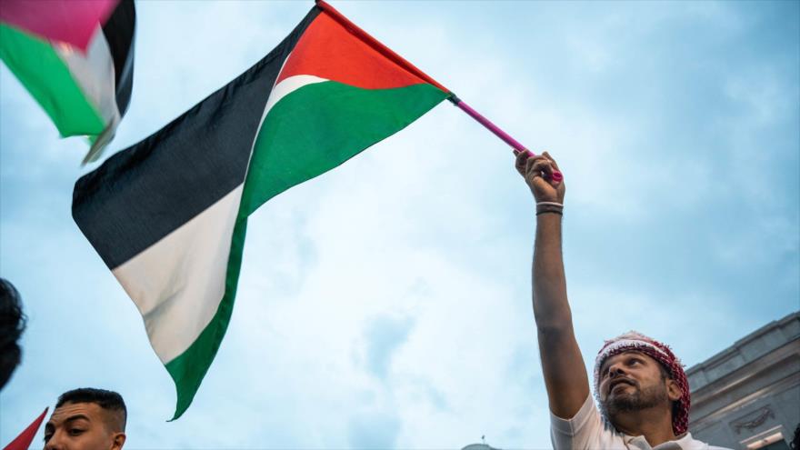 Un hombre con una bandera de Palestina durante una manifestación en apoyo al pueblo palestino
