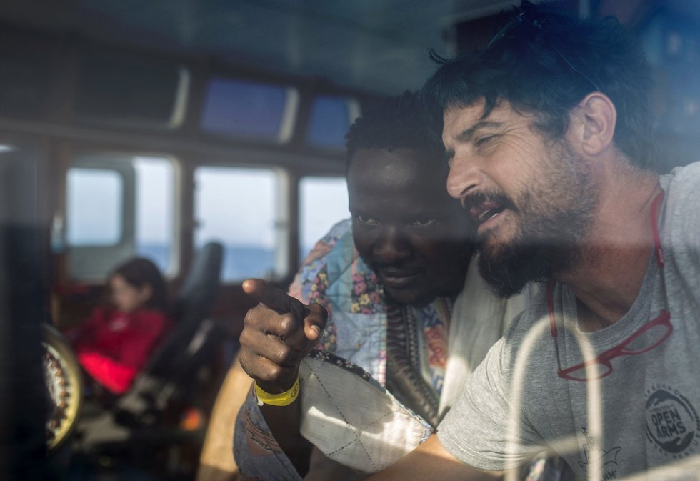 El Capitán del Open Arms Marco Matínez Esteban le ennseña el control del barco a Narcisse Saturnin Gbamago un migrante de 30 años de la República Centroafricana rescatado frente a la costa de Libia el 2 de julio