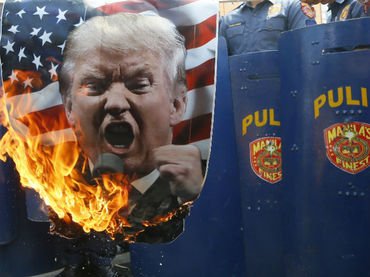 Un manifestante quema una imagen de Donald Trump durante una propuesta